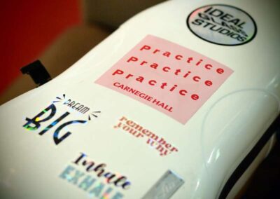 White surface with motivational stickers: Practice Practice Practice Carnegie Hall, Dream Big, Remember Your Why, Inhale Exhale.
